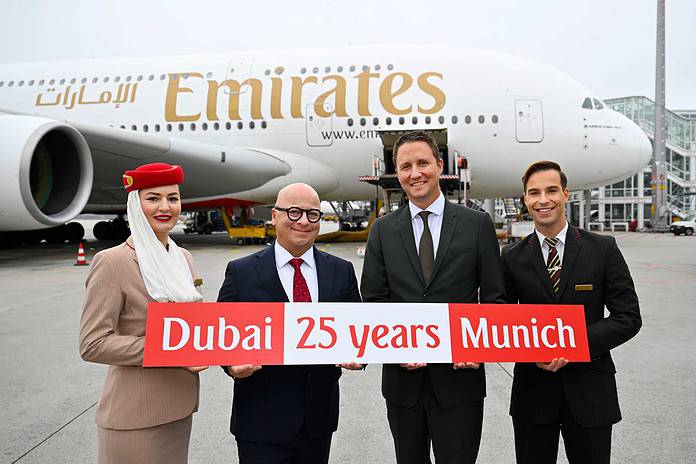 Emirates feiert 25 Jahre am Flughafen München: Joachim Sobottka-Rogalla, Emirates Airport Services Manager Munich (links), und Oliver Dersch, Senior Vice President Aviation, Flughafen München - flankiert von Mitgliedern der Emirates Kabinencrew.